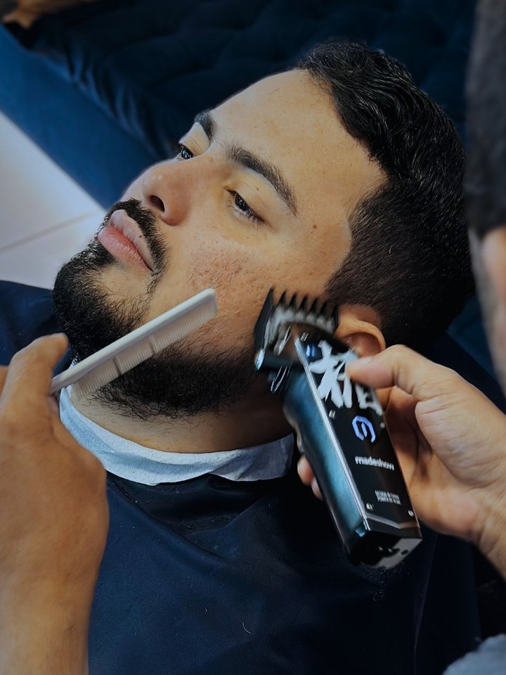 Barba sendo aparada com máquina e pente