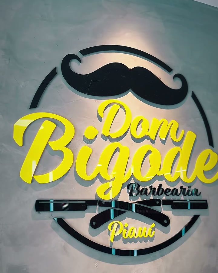 Logo Dom Bigode aceso na parede de cimento