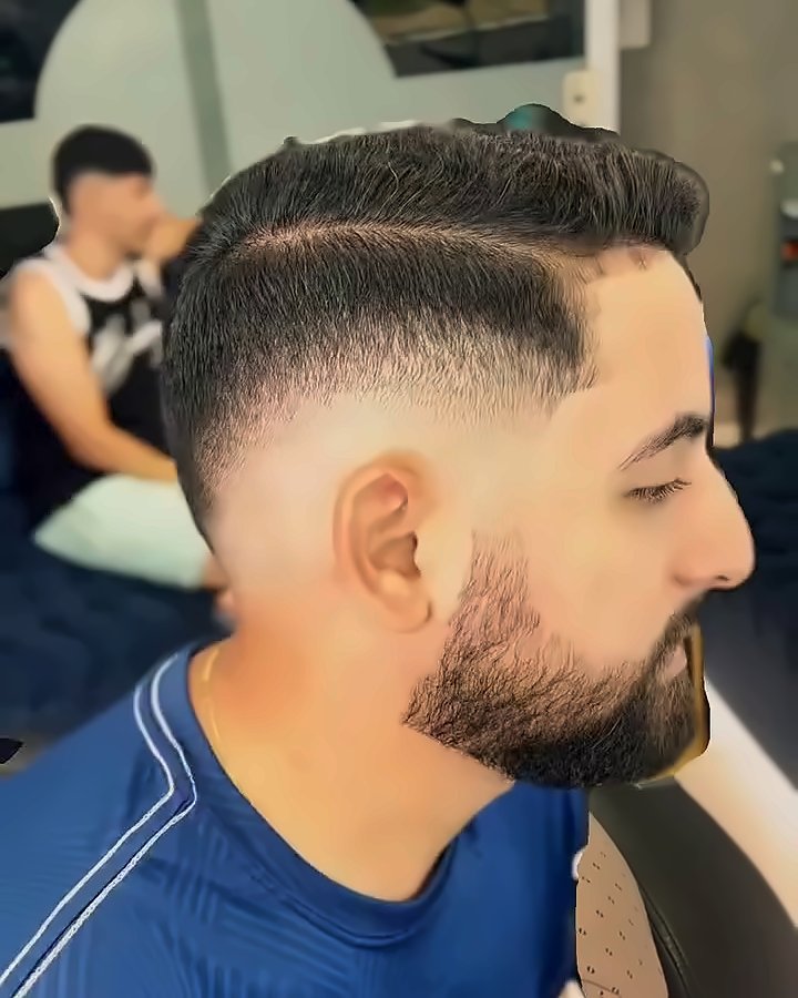 Degradê com risca e barba cheia, de perfil